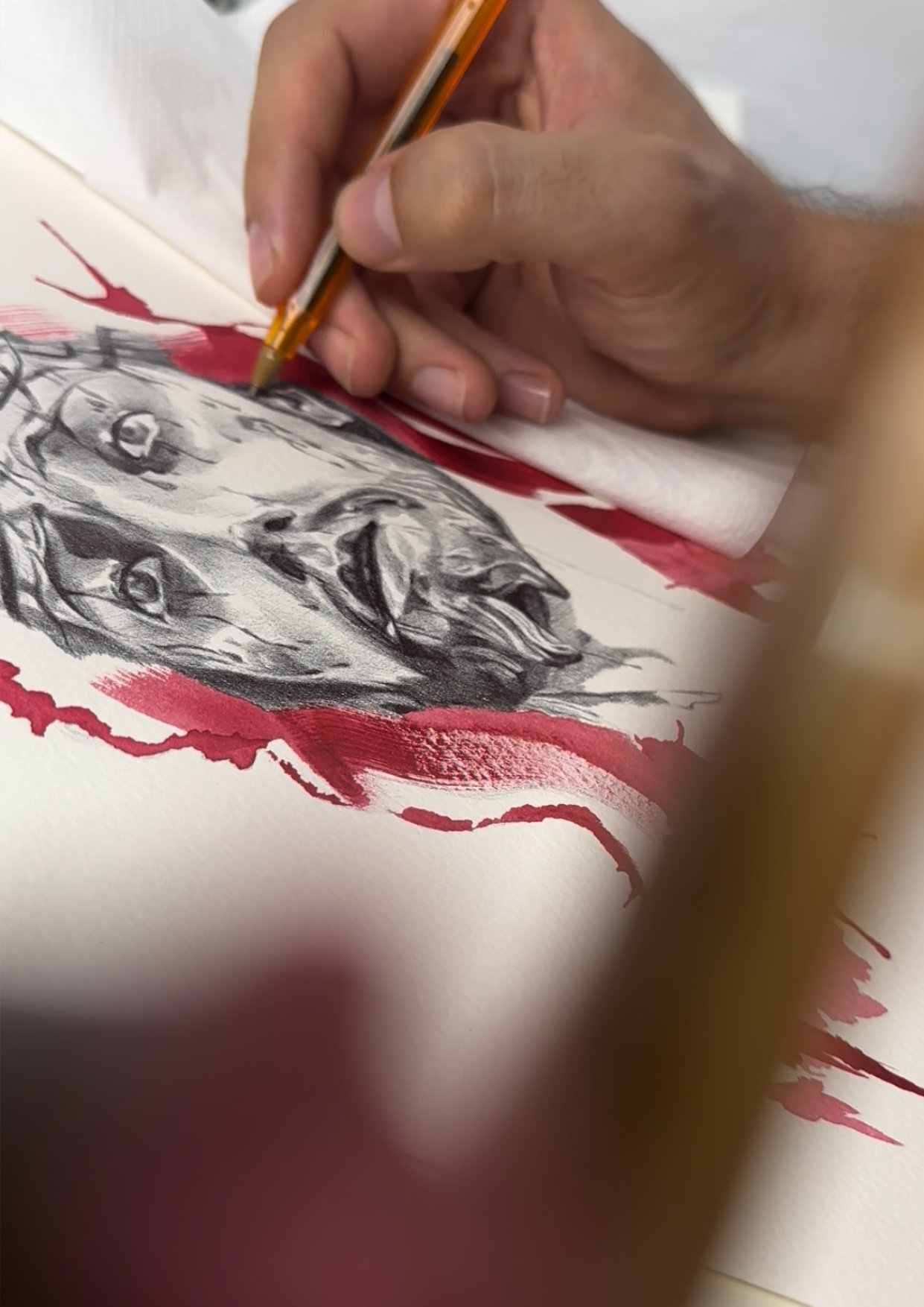 El artista dibujando a mano una obra de arte sacro con bolígrafo y acuarela roja