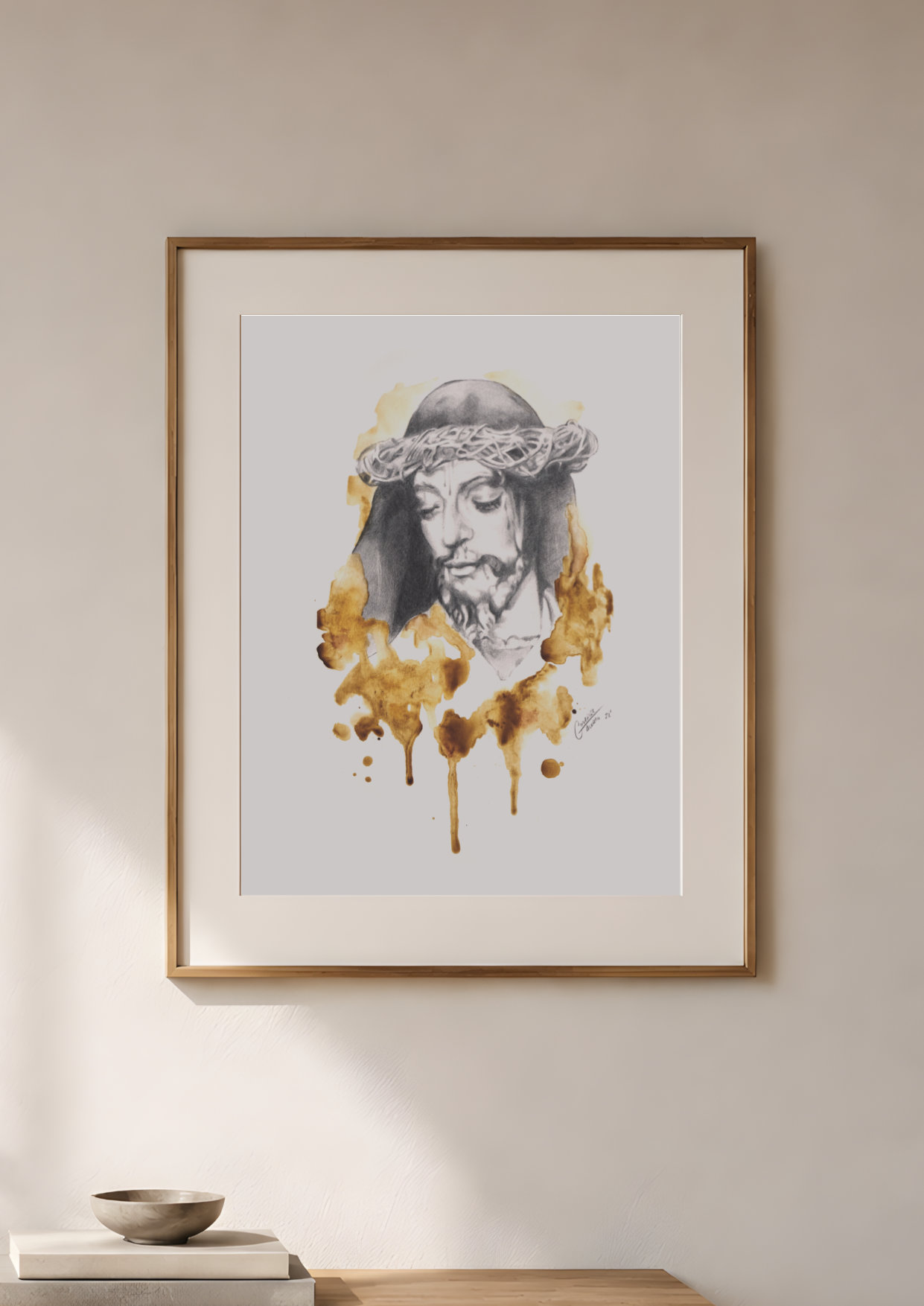 Obra de Cristo en grafito y café enmarcada sobre una pared clara
